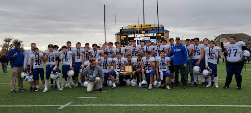 football team shows state championship trophy